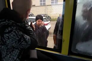 Un recluta ruso, de espaldas a la cámara, mira por la ventana de un autobús a su madre en un centro de reclutamiento militar en Volgogrado, Rusia, el sábado 24 de septiembre de 2022.