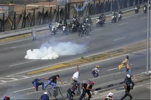 Manifestantes opositores a Maduro se enfrentan contra la policía, hoy en Caracas