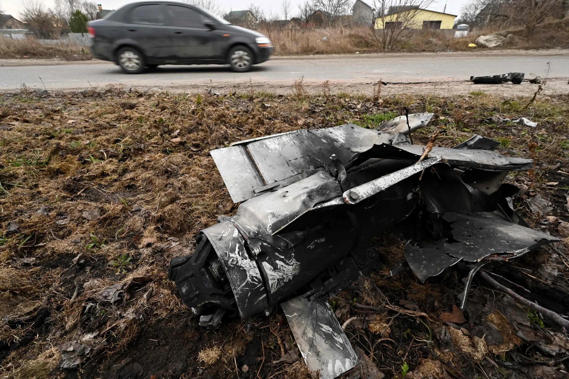 Un automóvil pasa junto a los restos a un cohete en un área residentncial en la capital ucraniana de Kiev