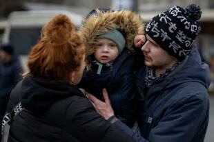 Tatiana, de 26 años, y Vlad, de 28 años, junto a su hijo Danya, de 2, en el la estación de ómnibus de Kiev, antes de dejar la capital. (AP Photo/Emilio Morenatti)