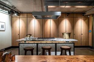 La cocina apuesta al estilo minimalista, y los armarios están ocultos detrás de paneles de madera