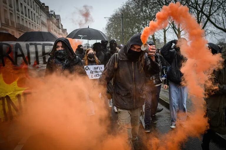 Un manifestante agita una granada de humo durante una manifestación convocada por sindicatos franceses en Nantes, en el oeste de Francia, el 19 de enero de 2023
