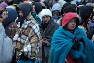 En esta imagen de archivo, refugiados, en su mayoría mujeres y niños, esperan junto a más gente para ser trasladados luego de llegar al paso fronterizo de Medyka, en Polonia, huyendo de la guerra en Ucrania, el 7 de marzo de 2022. (AP Foto/Markus Schreiber, archivo)