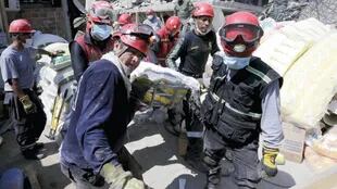 Rescatistas trasladan los restos de una de las víctimas de la destrucción de un edificio en Pedernales.