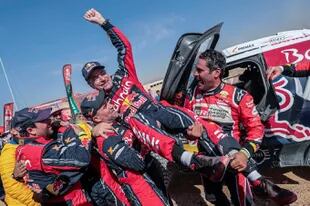 El español Carlos Sainz, celebra junto al francés Stephane Peterhansel y Nasser Al-Attiyah de Qatar, al coronarse campeón del Dakar 2020