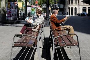 Dos adultos mayores durante las horas en que pueden estar al aire libre, en Barcelona.