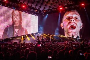 Chris Martin en las pantallas junto a Gustavo Cerati, cantando a dúo  "De música ligera"