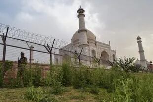 Un miembro del personal de seguridad hace guardia detrás de una valla perimetral en el Taj Mahal.