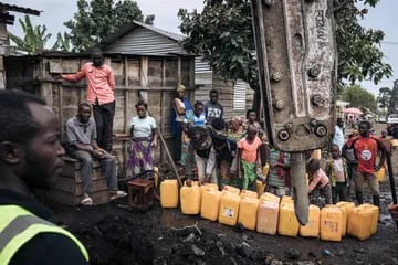 Los habitantes de Goma recolectan agua mientras los trabajadores reparan las líneas eléctricas destruidas por el flujo de lava del volcán Nyiragongo