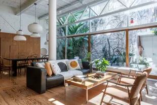 Junto al piso y las paredes, los muebles de madera combinan a la perfección con el verde de las plantas.