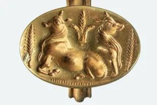 En el anillo de oro están representados dos toros flanqueados por tallos de cebada