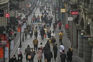 La gente camina por una calle peatonal en Wuhan, provincia central de Hubei en China, el 23 de enero de 2021, un año después de que la ciudad se cerrara para frenar la propagación del coronavirus