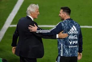 Pekerman y Messi se saludan durante el calentamiento para el partido que la Argentina le ganaría a Venezuela en La Bombonera; el entrenador recibió de AFA una plaqueta.