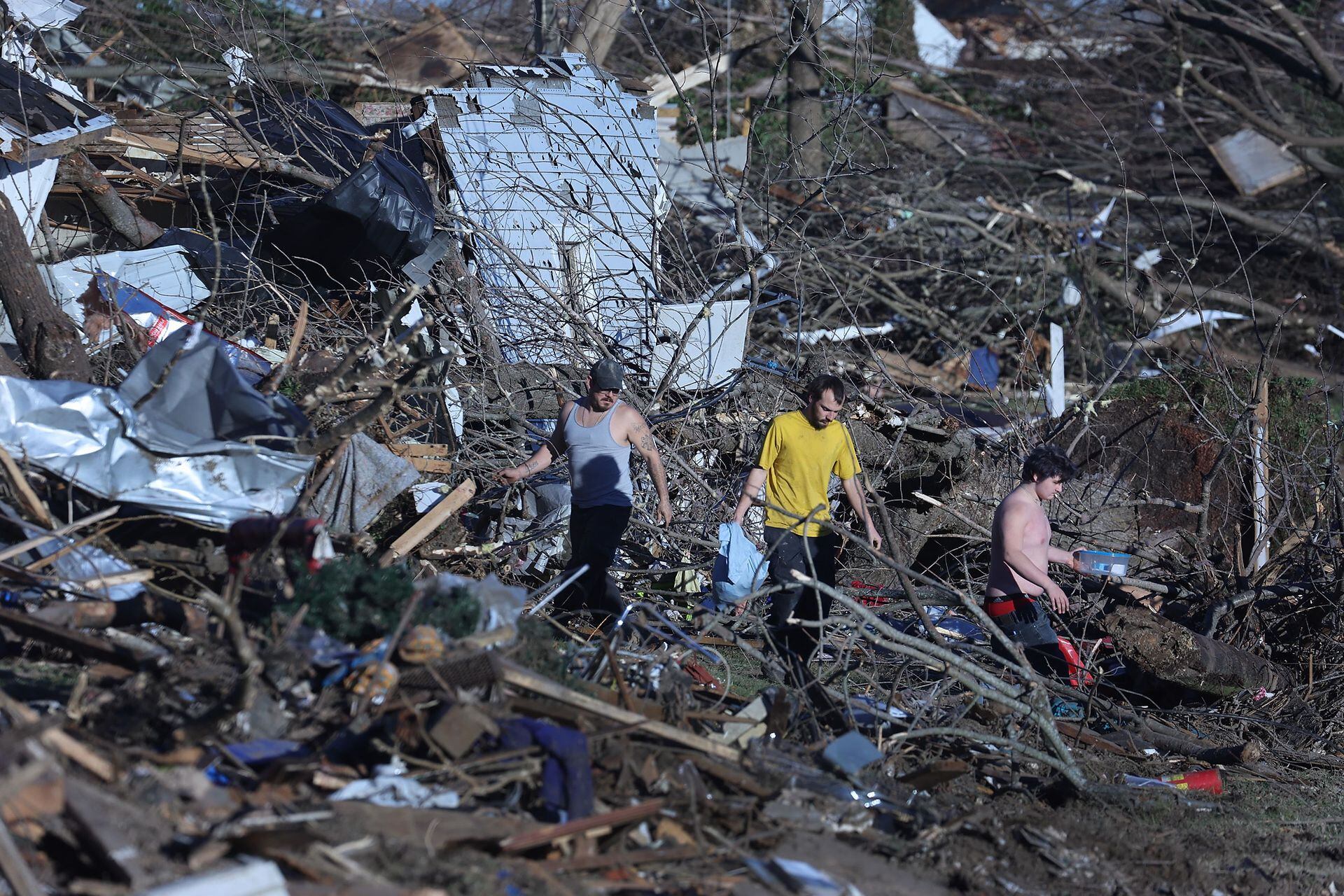 Los residentes rescatan pertenencias de las casas destruidas después de que un tornado arrasó una gran parte de la ciudad