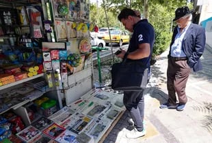 Los iraníes revisan los diarios en la capital, Teherán, el 13 de agosto de 2022