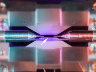 La flecha indica dónde está el reflejo generado por el rebote del láser en el átomo; la distancia entre los electrodos es de 2 milímetros