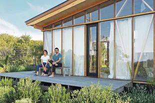 Delfina y Franco posan en su hogar hecho con estructura de multilaminado de eucalipto y vidrios dobles con cámara de aire.