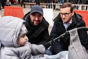 El presidente del Consejo Europeo, Charles Michel, y el primer ministro polaco, Mateusz Morawiecki, interactúan con un bebé durante una visita a la frontera ucraniano-polaca en Korczowa.