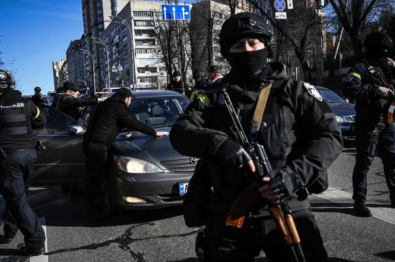Policías ucranianos paran los coches para controlar a la gente mientras buscan a hombres sospechosos, el 27 de febrero de 2022 en una calle de Kiev.