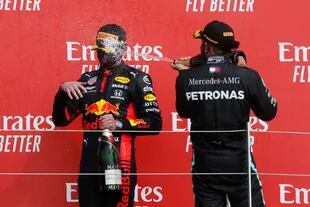 Max Verstappen recibe el baño de champagne de Lewis Hamilton en el podio de Silverstone; el neerlandés saltó al segundo puesto del Campeonato de Pilotos que lidera el séxtuple campeón británico