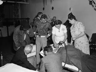 Los bomberos voluntarios y las enfermeras del pueblo, asistiendo a los enfermos con tanques de oxígeno el 30 de octubre de 1948 (National Geographic)