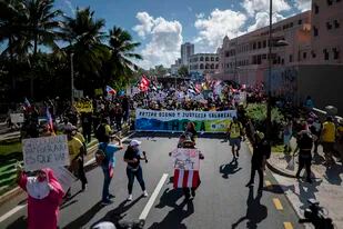 Manifestantes del sector de la educación pública marchan por una calle de San Juan, Puerto Rico, para exigir un aumento salarial, pensiones adecuadas y la mejora de las condiciones laborales, el 9 de febrero de 2022. (AP Foto/Carlos Giusti)