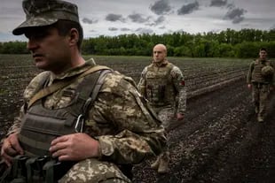 Roman Kachur (tengah), komandan Brigade Artileri Terpisah ke-55 Ukraina, berjalan ke posisi menembak di wilayah Donetsk