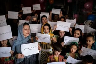 Mujeres y maestras se manifiestan en una escuela privada para exigir sus derechos y la igualdad de educación para mujeres y niñas, durante una reunión por el Día Nacional del Maestro el martes 5 de octubre de 2021 en una escuela privada en Kabul, Afganistán. (AP Foto/Ahmad Halabisaz)
