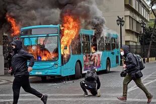 Auf diesem Foto vom 27. Mai 2022 fängt ein Bus während eines Studentenmarsches in Santiago Feuer, der die Regierung auffordert, ihr Bildungssystem zu verbessern.