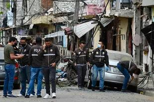Miembros de la Policía Nacional inspeccionan el lugar de una explosión