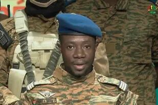 Esta captura de video tomada de un video obtenido por AFPTV de Radio Télévision du Burkina (RTB) el 24 de enero de 2022 muestra al capitán Sidsoré Kader Ouedraogo, vocero de la junta, con soldados uniformados anunciando en televisión que tomaron el poder