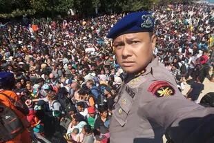 El jefe de la policía de Lombok, Dewa Wijaya, se toma una fotografía frente a cientos de personas que intentan abandonar Gili Trawangan, al norte de la vecina La isla de Lombok