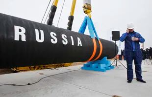 Un lavoratore russo parla al cellulare nella baia di Portovaya, a circa 170 chilometri (106 miglia) a nord-ovest di San Pietroburgo, Russia, venerdì 9 aprile 2010, durante una cerimonia di inaugurazione del gasdotto Nord Stream. 