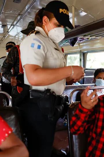 En un puesto de control en Pajapita, Guatemala, un policía revisa la documentación de los pasajeros para verificar si hay migrantes provenientes de la caravana de centroamericanos, para evitar que continúen su viaje hacia Estados Unidos