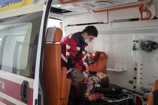 Oleksandr Konovalov, paramédico de una ambulancia, realiza la reanimación cardiopulmonar a una niña herida por un bombardeo en una zona residencial mientras su padre está sentado, a la izquierda, tras llegar al hospital de la ciudad de Mariupol, en el este de Ucrania, el domingo 27 de febrero de 2022. La niña no sobrevivió.