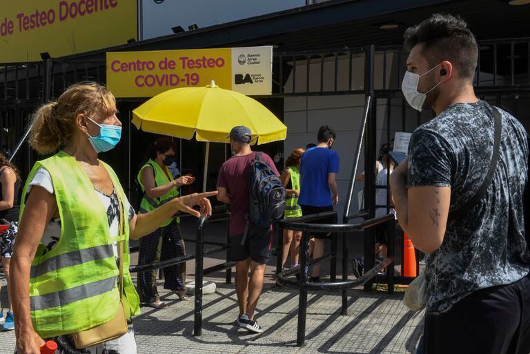 Una trabajadora de salud da instrucciones fuera del Parque Centenario mientras esperan pruebas gratuitas de Covid-19