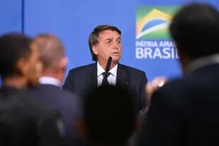 Brazilian President Jair Bolsonaro speaks during an act in defense of freedom of expression at Planalto Palace in Brasilia, on April 27, 2022. - Brazilian President Jair Bolsonaro defended his decision to grant a pardon to a controversial ally convicted of attacking democratic institutions, saying "I free people who are innocent." The far-right president has come in for criticism since pardoning Congressman Daniel Silveira, a day after the Supreme Court sentenced the 39-year-old lawmaker to eight years and nine months in prison for his role leading a movement calling for the court to be overthrown. (Photo by EVARISTO SA / AFP)