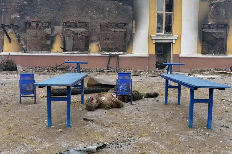 Un cuerpo de un soldado ruso yace fuera de una escuela destruida como resultado de la lucha en Kharkiv el 28 de febrero de 2022. 