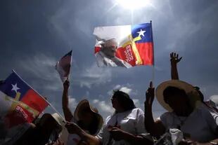 Los asistentes a la misa agitan banderas chilenas con la imagen de Francisco