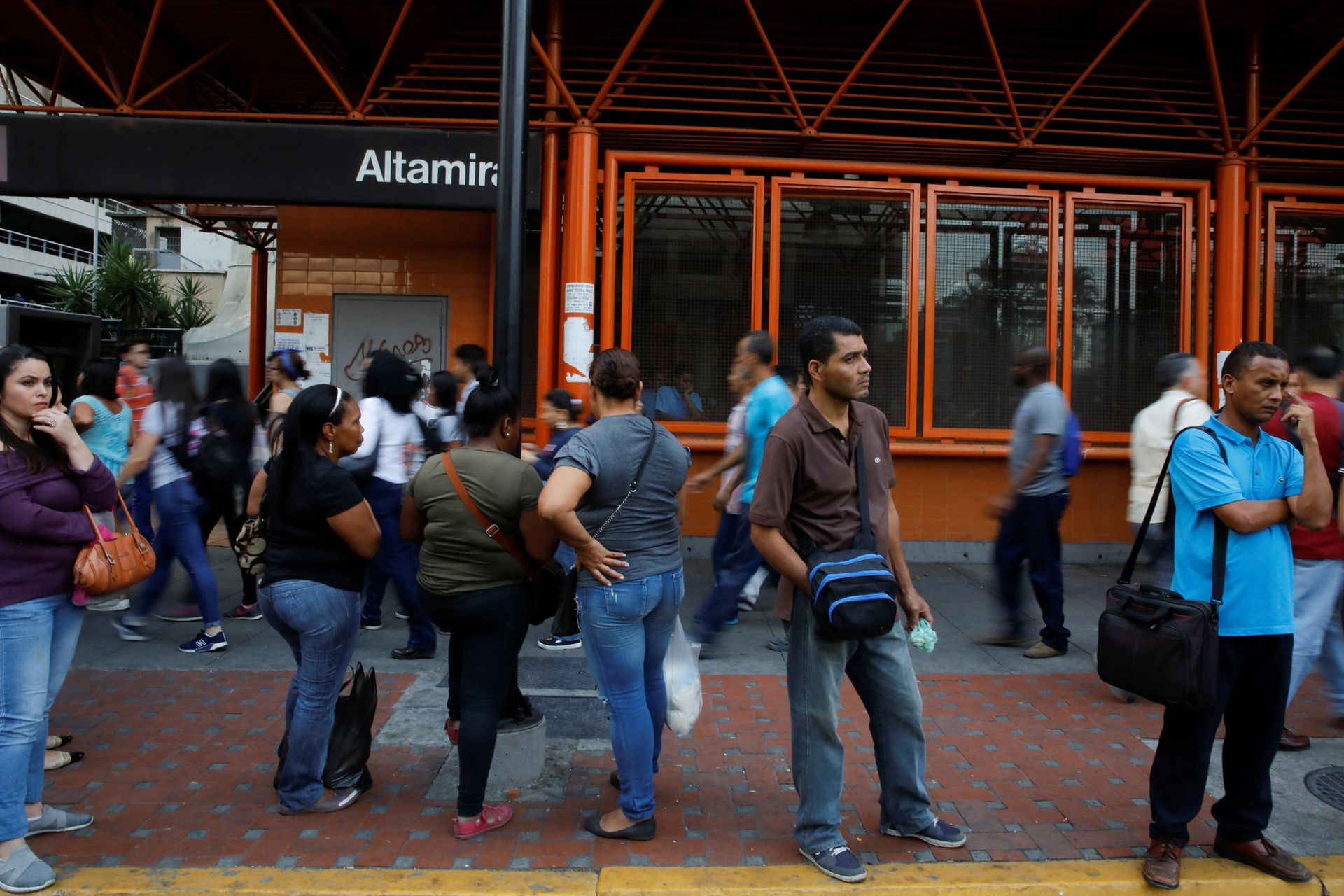 La gente camina frente a una estación de metro cerrada durante un apagón en Caracas, Venezuela.