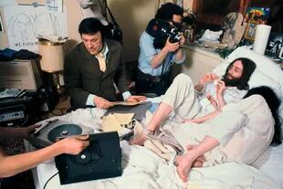 John Lennon y Yoko Ono en 1969 en la cama del Hotel Queen Elizabeth, en Montreal, mientras el legendario DJ de Nueva York Murray the K transmite en vivo y un camarógrafo los filma