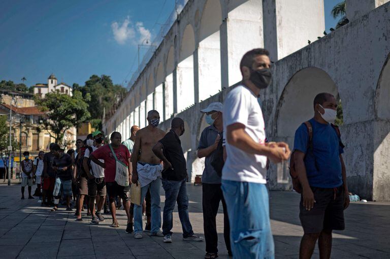 Filas en Río de Janeiro para obtener un plato de comida (Photo by MAURO PIMENTEL / AFP)