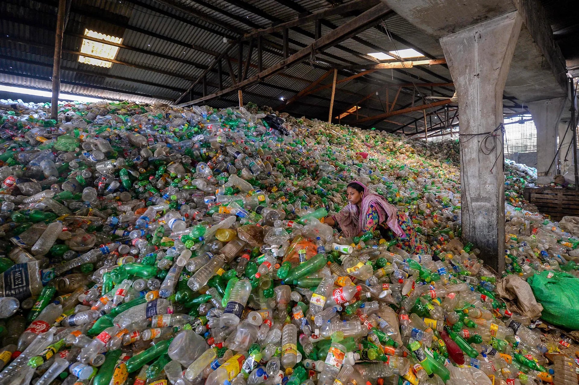 Un trabajador clasifica botellas de plástico usadas en una fábrica de reciclaje en Dhaka.