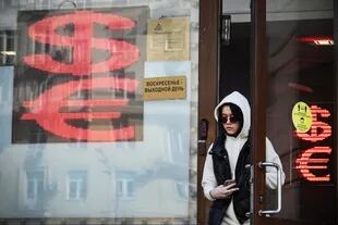 Una mujer sale de una oficina de cambio de moneda en el centro de Moscú el 18 de abril de 2022. 