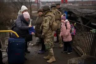 Soldados ucranianos controlan los documentos de los ciudadanos que huyen de la guerra