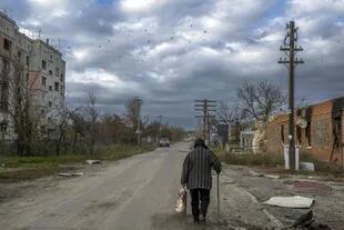 Un hombre camina en la ciudad de Kherson, ocupada hasta hace poco por los rusos. (Photo by BULENT KILIC / AFP)