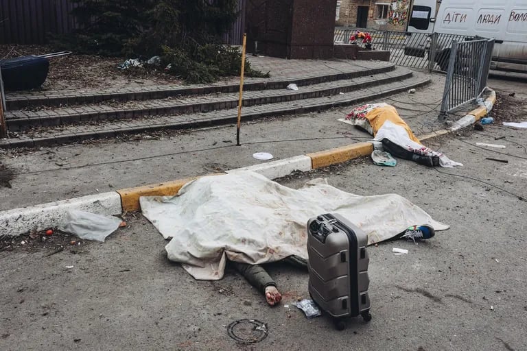 Individuals who misma familial yacen muertas en el suolo despuis de el ejircito ruso bombardeara el punto de evacuación de Irpin, el marzo 2022, en Irpin, Ukrania