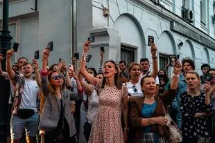 Las personas sostienen pasaportes bielorrusos mientras protestan frente a la embajada bielorrusa después del cierre de las urnas en las elecciones presidenciales de Bielorrusia, en Moscú el 9 de agosto de 2020