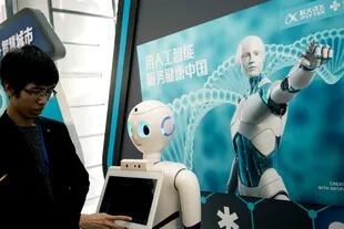 Un hombre programa un robot durante una exhibición tecnológica en Pekín