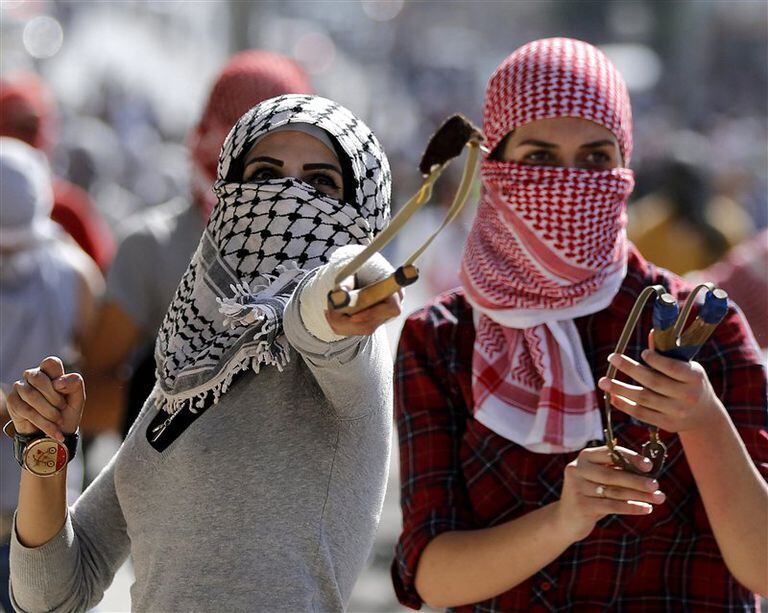 Dos manifestantes palestinas arrojan piedras durante un enfrentamiento en Belén